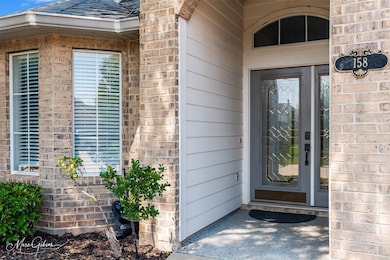 Entrance to property featuring brick siding and a shingled roof