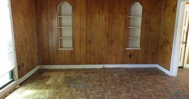Unfurnished room featuring wood walls
