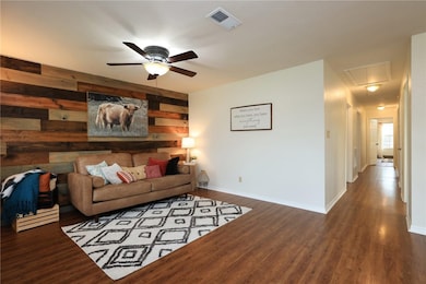Living area featuring attic access, wood walls, a