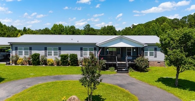 Ranch-style home with a porch, a front yard, a metal roof, and crawl space
