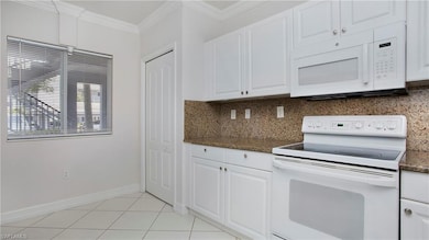 Kitchen featuring white appliances, decorative bac