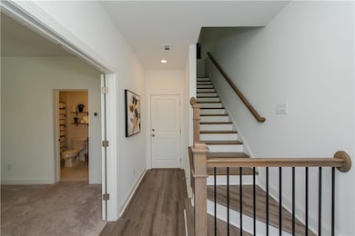 Stairway featuring baseboards, wood finished floors, and recessed lighting
