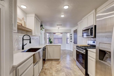 Kitchen featuring kitchen peninsula, light tile fl