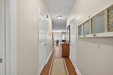 Hall featuring dark wood-type flooring and a textured ceiling