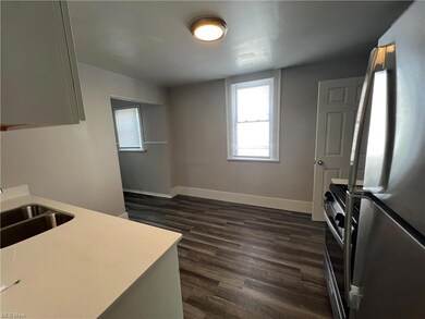 Kitchen featuring dark hardwood floors and appliances with stainless steel finishes