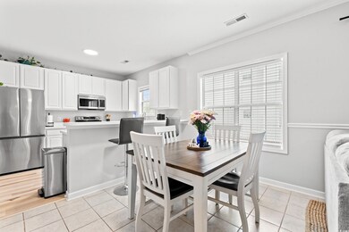 Dining area with crown molding and light hardwood 