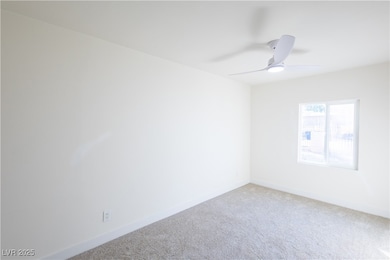 Empty room with light carpet, a ceiling fan, and b