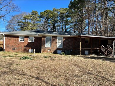 Back of house with central AC, brick siding, and c