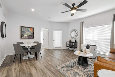 Living area with light wood-style floors, recessed lighting, and a ceiling fan