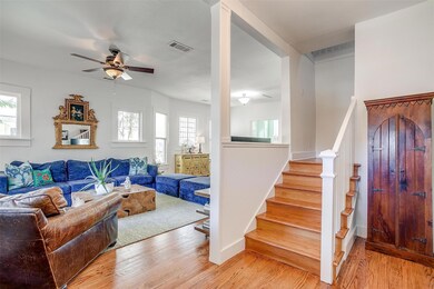 Living room with ceiling fan and light hardwood / 