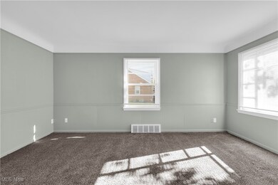 Carpeted empty room featuring wainscoting and baseboards