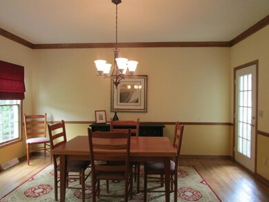 The formal dining room features crown molding, chair rail, newer hardwood flooring, and access to the wrap around front porch.