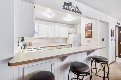 Kitchen featuring a breakfast bar area, white appl
