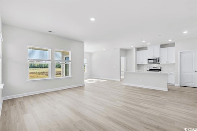 Unfurnished living room with baseboards, light woo