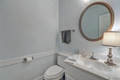 The half bath has chair rail and hardwood floor.