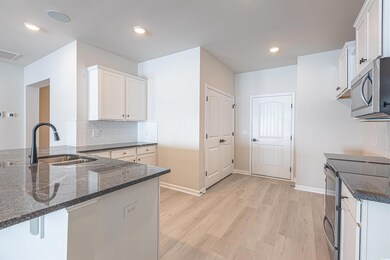 Kitchen with white cabinets, kitchen peninsula, an