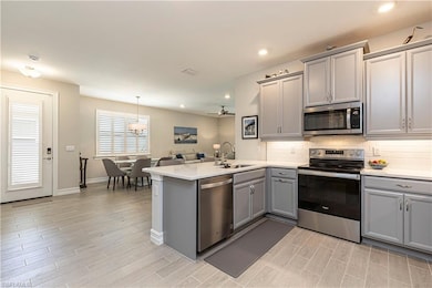 Kitchen featuring grey cabinets, Stainless Steel appliances, & quartz countertops