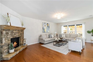 Living room featuring wood finished floors, baseboards, and a fireplace