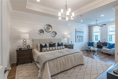 This spacious Chamberlain primary bedroom is a serene retreat, designed for both comfort and elegance.  This photo is of the model home and does not represent this homesite.
