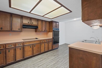 Kitchen featuring a sink, under cabinet range hoo