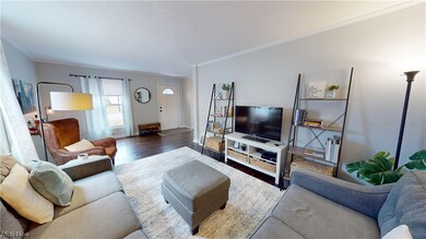Living room with hardwood / wood-style flooring and crown molding