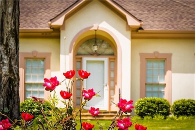 Doorway to property with a shingled roof and stucc