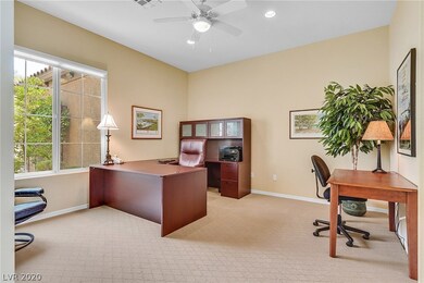 Spacious den with neutral paint and ceiling fan.