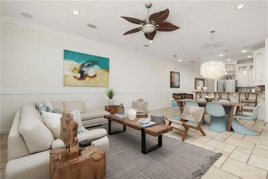 Living room with recessed lighting, a ceiling fan, crown molding, a chandelier, and stone tile floors