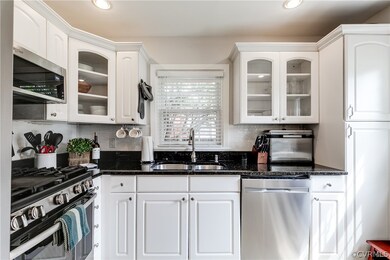 Kitchen featuring white cabinetry, stainless steel