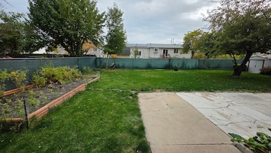 Fenced backyard with a vegetable garden and a storage unit