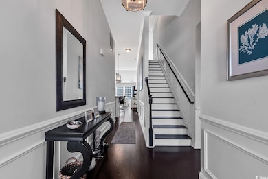 Entryway with dark wood-type flooring and crown mo