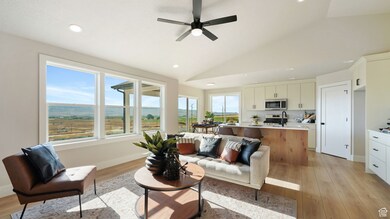 Living area with recessed lighting, vaulted ceiling, ceiling fan, and light wood-style floors