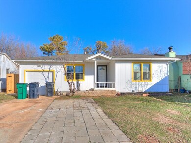 Single story home featuring a front yard and a gar