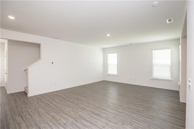 Spare room with a smoke detector, wood finished floors, stairway, and recessed lighting