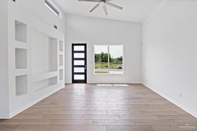 Spare room with high vaulted ceiling, ceiling fan, light hardwood / wood-style floors, and built in shelves