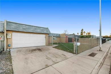 View of front facade featuring a garage, concrete driveway, a fenced front yard, and stucco siding