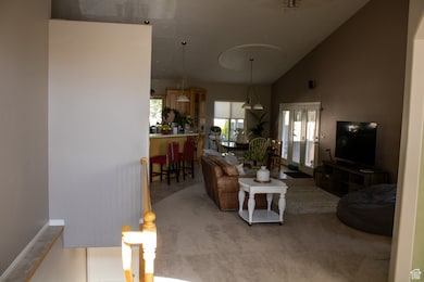 Living area featuring lofted ceiling and carpet flooring