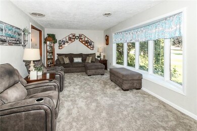 Large living room with new paint and carpet, huge bay window for loads of natural light, flows to kitchen and dining room.  One of three common areas for entertaining and family gatherings!
