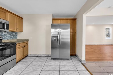 Kitchen featuring backsplash, appliances with stai