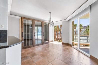 Unfurnished dining area with crown molding, a chandelier, light tile patterned floors, and baseboards