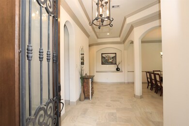 GRACIOUS ENTRY HALL:   Wide and welcoming, this entry hall greets you with outstanding architectural details.   The art niche at the end of the hallway can highlight a favorite piece.  The tray ceiling with double crown molding makes a statement that this home is special.
