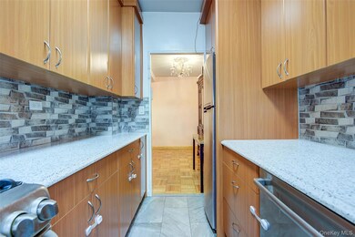 Kitchen featuring backsplash, light stone countertops, brown cabinetry, and dishwasher