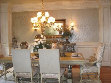 Dining space featuring wallpapered walls, a chande