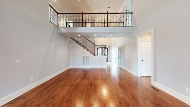 View from the living room fireplace showcasing the catwalk and stairs leading up to the three large secondary bedrooms located upstairs.