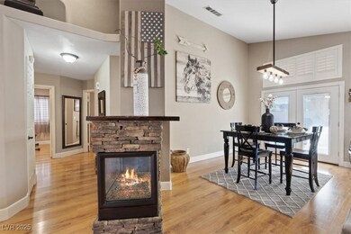 Dining area with wood finished floors, french doors, and a fireplace