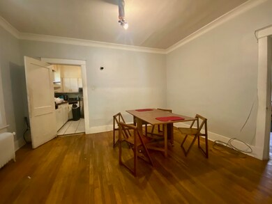 Tiled dining space featuring crown molding