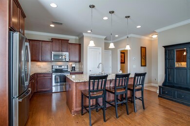 The spacious Kitchen has granite counters, tile backsplash, undercabinet lights, pantry, crown molding, recessed lights and pendants over the 7' x 4' island.  There is also a Powder Room and back hall leading to the 2 car garage.
