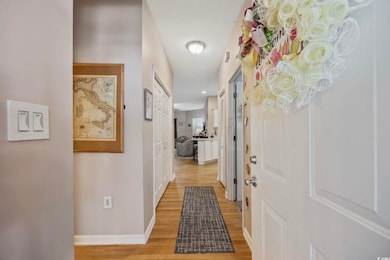 Corridor with light wood-type flooring and baseboards