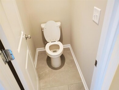 Bathroom with toilet, tile patterned flooring, and baseboards
