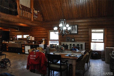 Dining space with high vaulted ceiling, a chandelier, and wooden ceiling